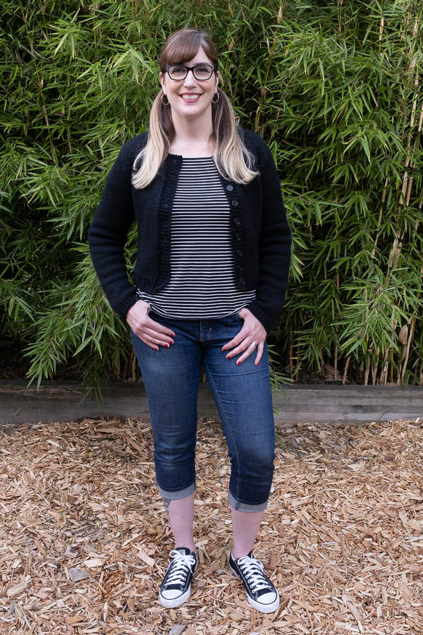 On -figure full length front photo of a hand knit black cardigan knit with Harrisville Designs Highland yarn and using the CustomFit Inlet Cardigan pattern